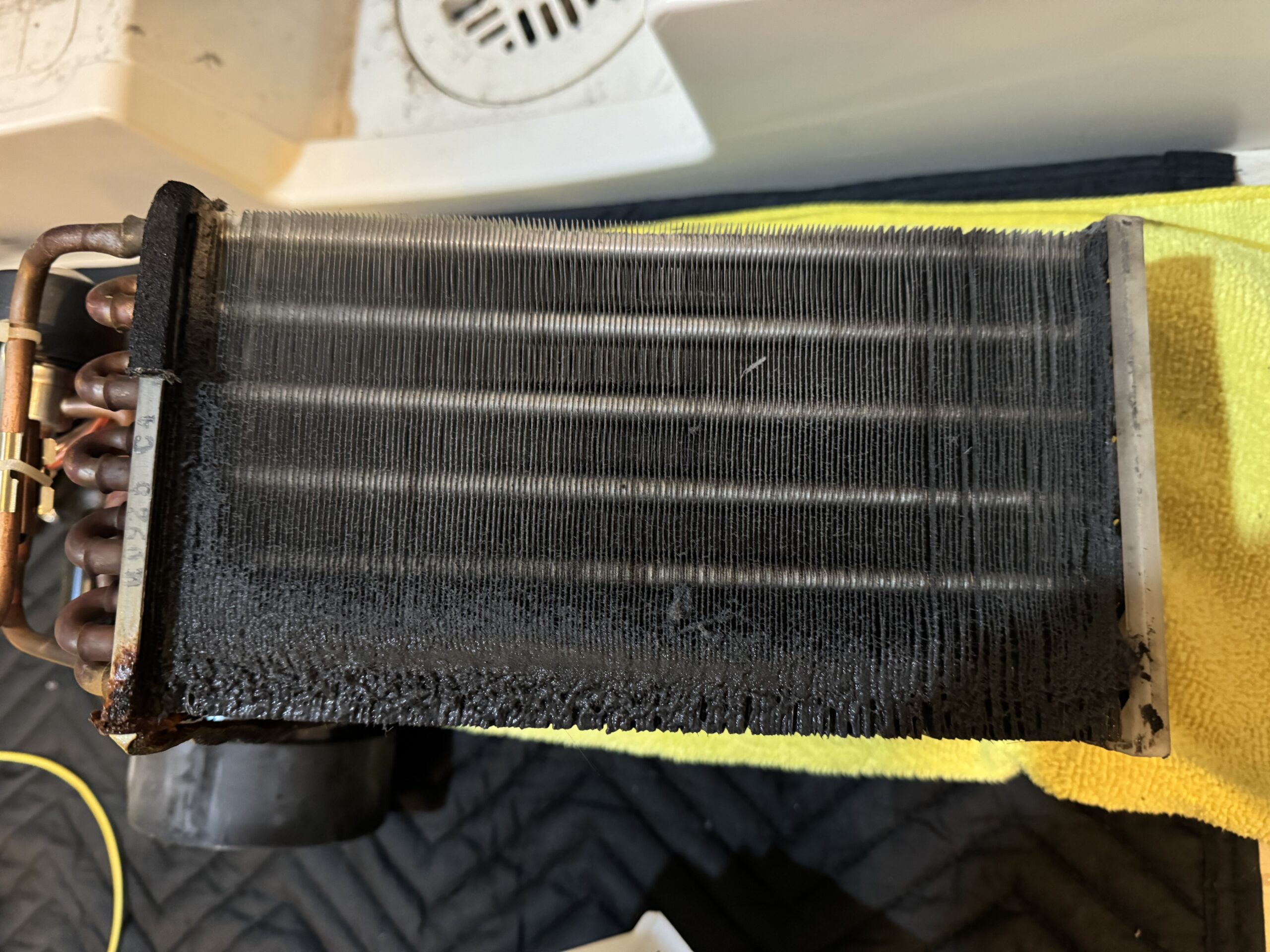 ホコリで真っ黒に目詰まりしたヒートポンプの熱交換器フィン