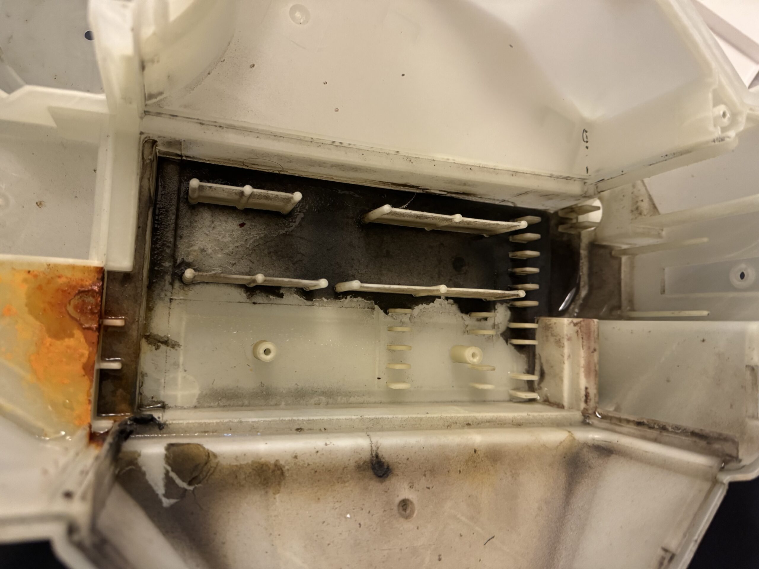 黒カビやサビで汚れたヒートポンプユニット内部カバー