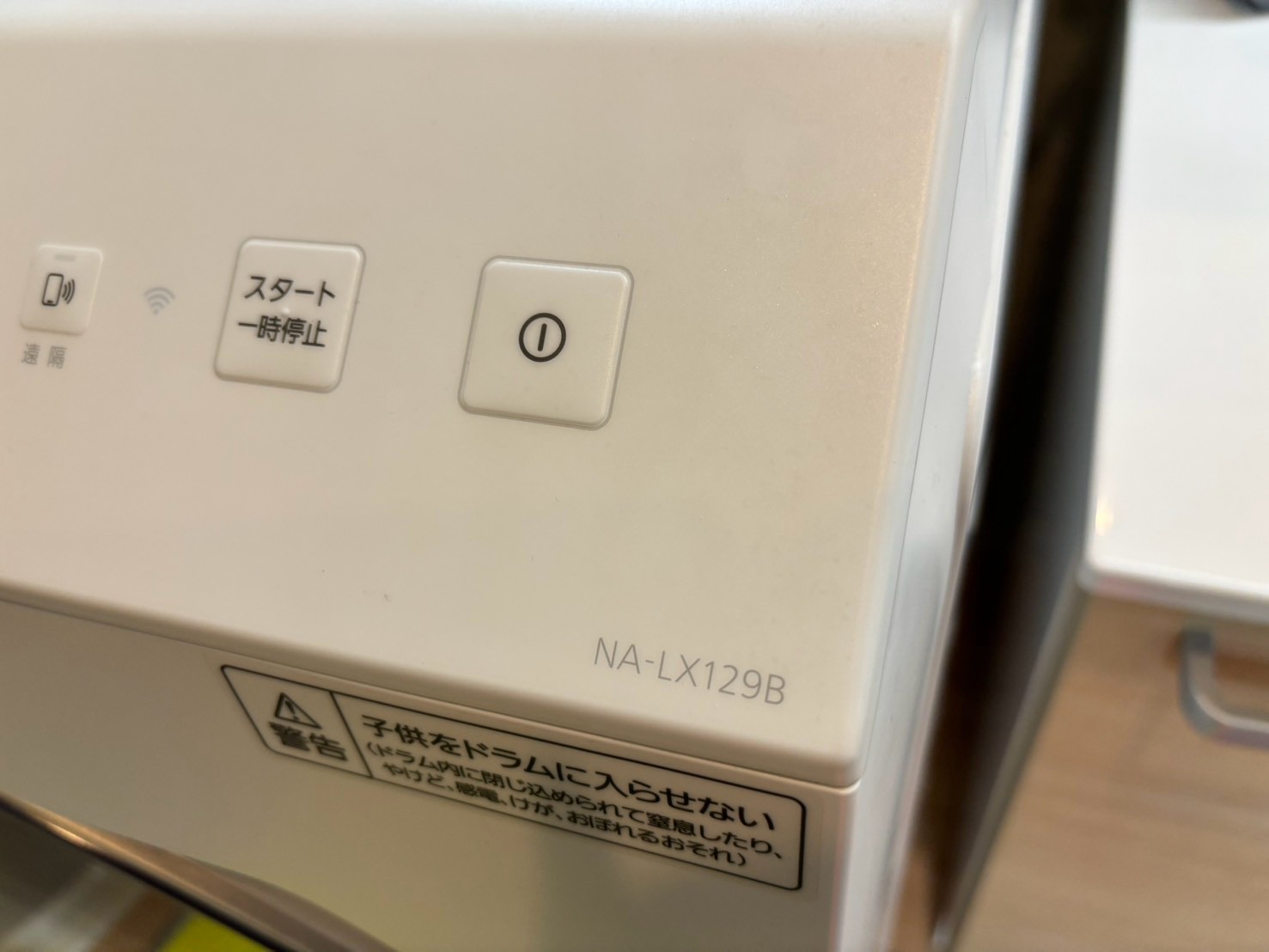 型番プレートのクローズアップ。NA-LX129Bと表示されている